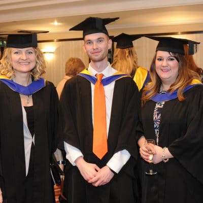 graduates at graduation stood next to one another