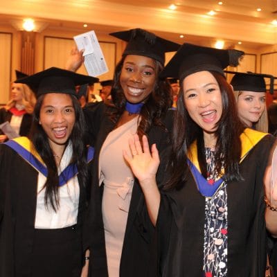 3 students graduation smiling