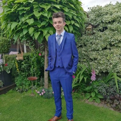 Jamie Spensley stands in his garden in a suit.