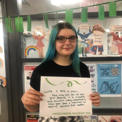 Student with advice on a poster for mental health day at Solihull College