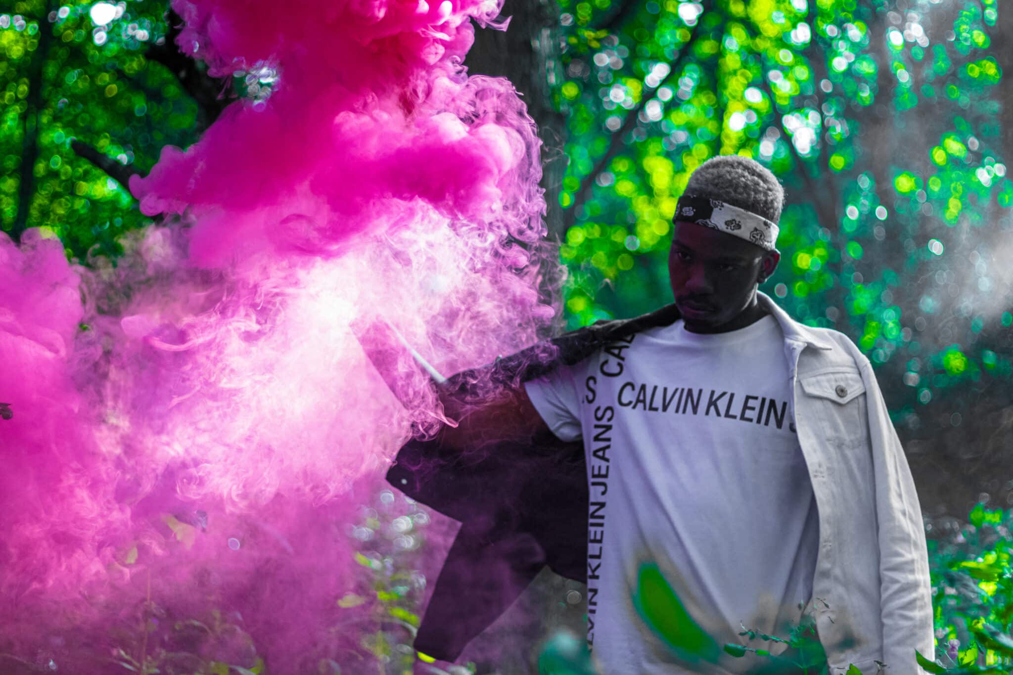 Man in forest with pink smoke