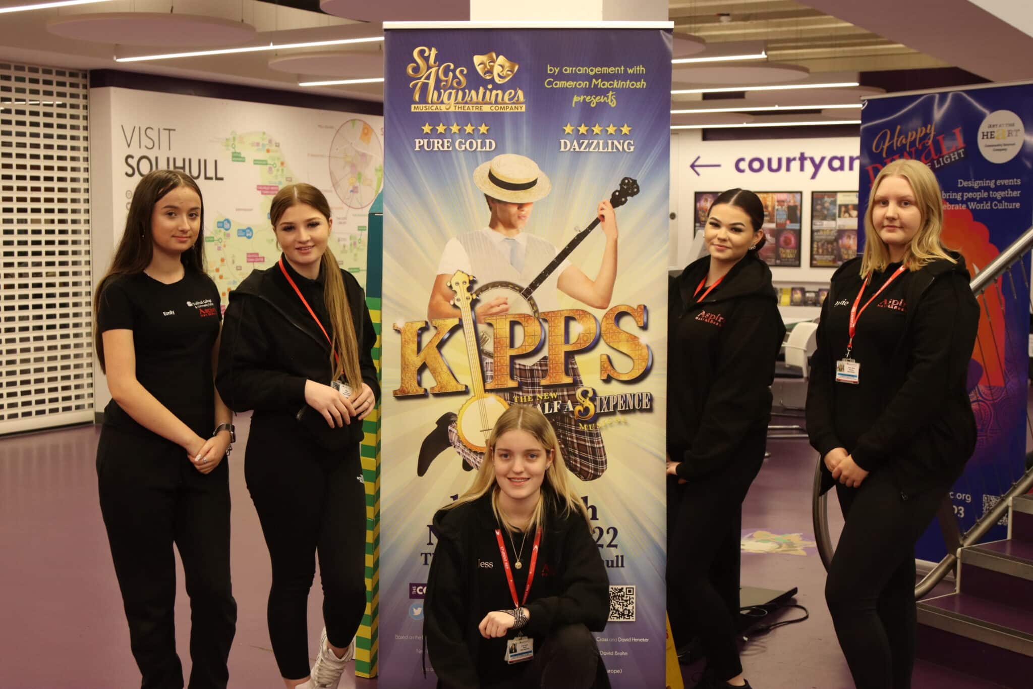 students wearing black standing in front of KIPPS promotional banner