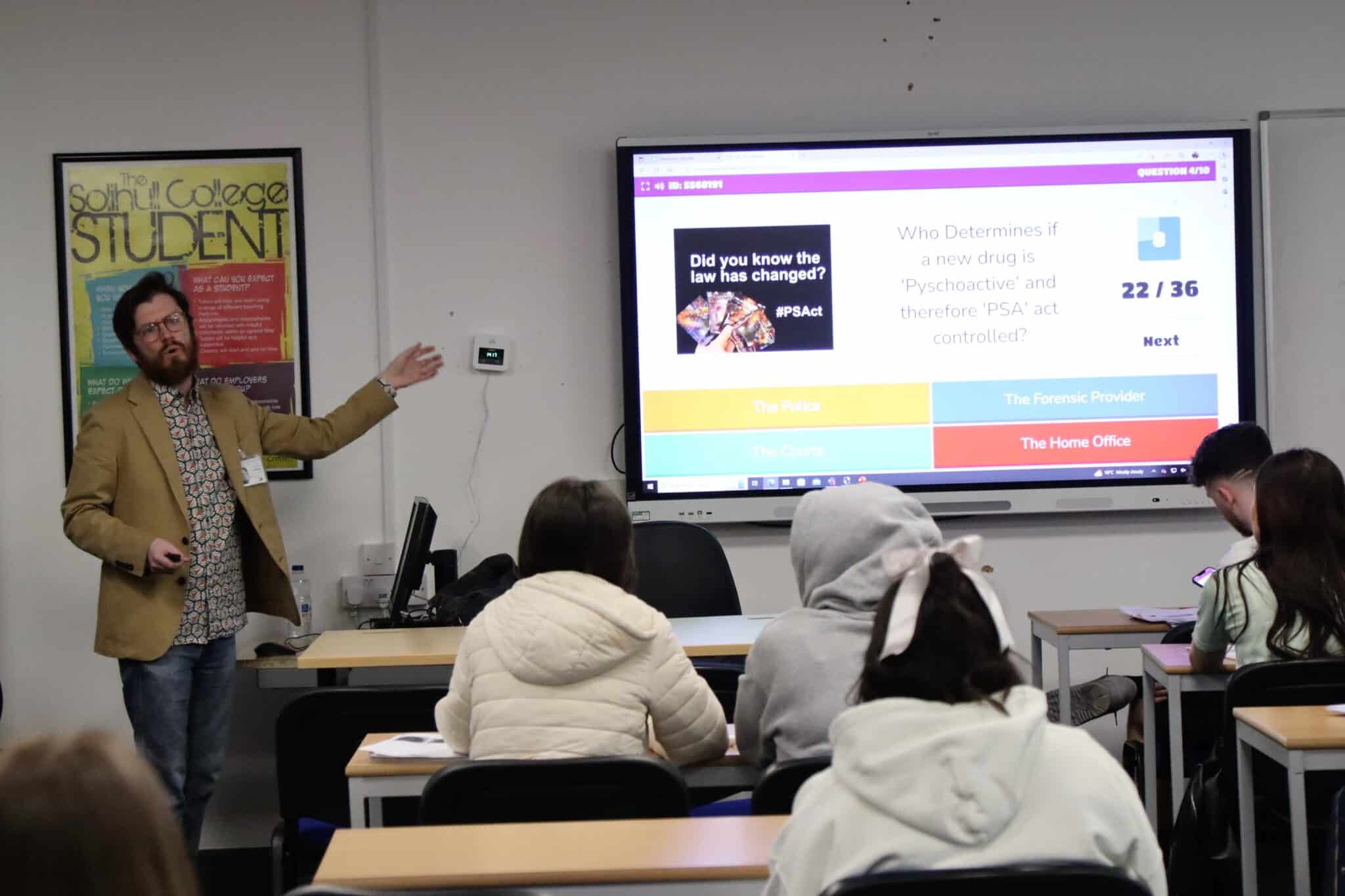 visitor pointing at screen as he delivers drug analysis session