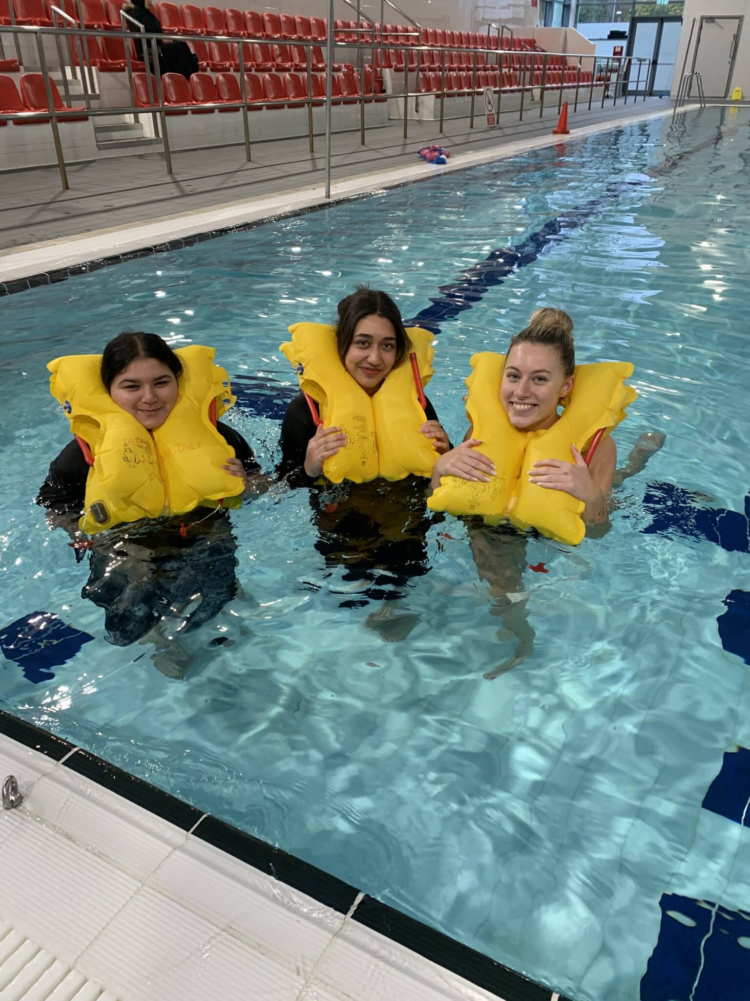 cabin crew students wearing life jackets in the pool
