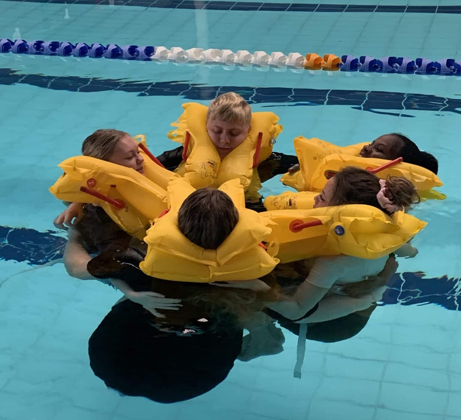 cabin crew students with life jackets in the pool at Tudor Grange