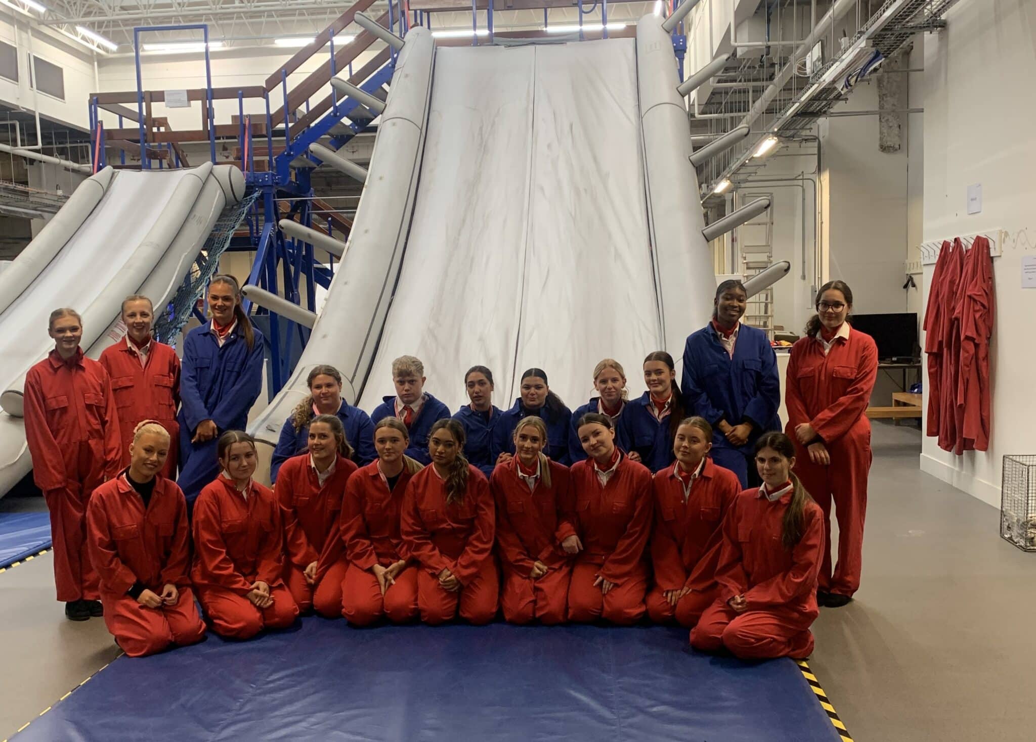 cabin crew students standing in front of a huge slide