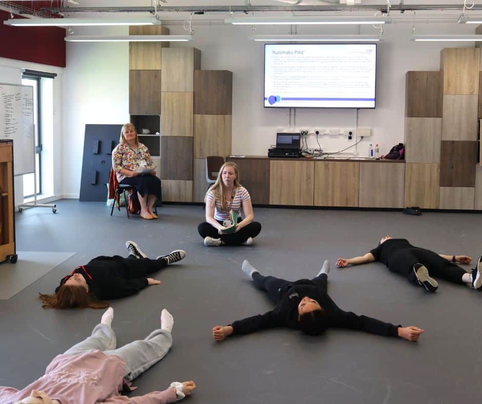 students lying on floor during mental health workshop