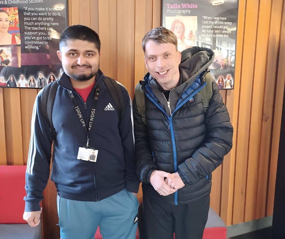 Two students looking at camera and smiling