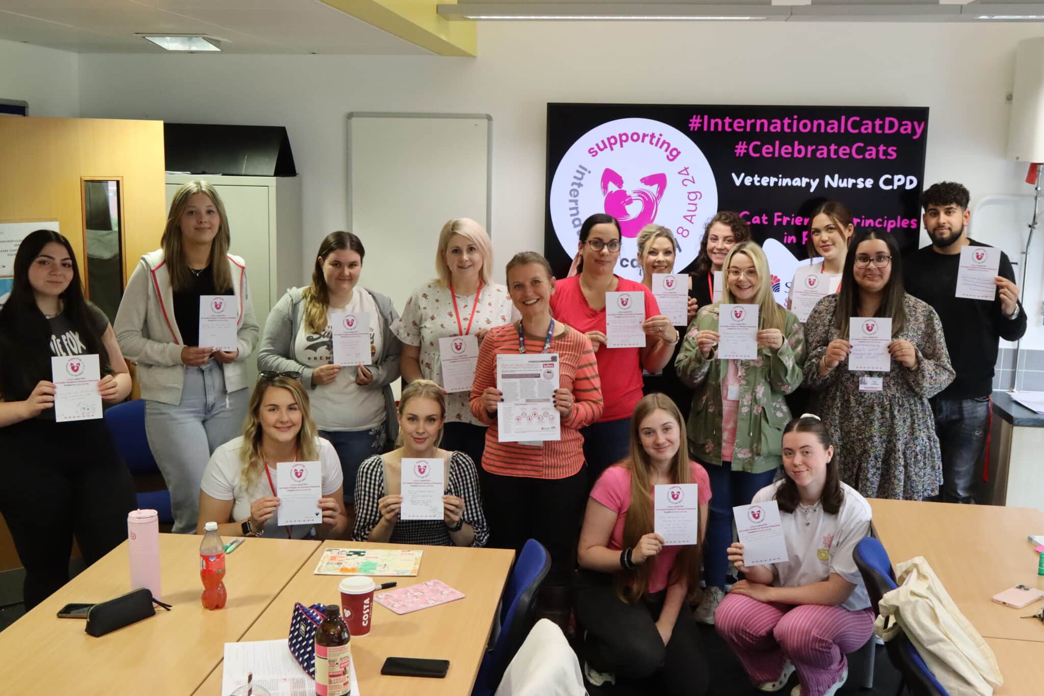 group of students with lecturer holding up pledges to protect cats