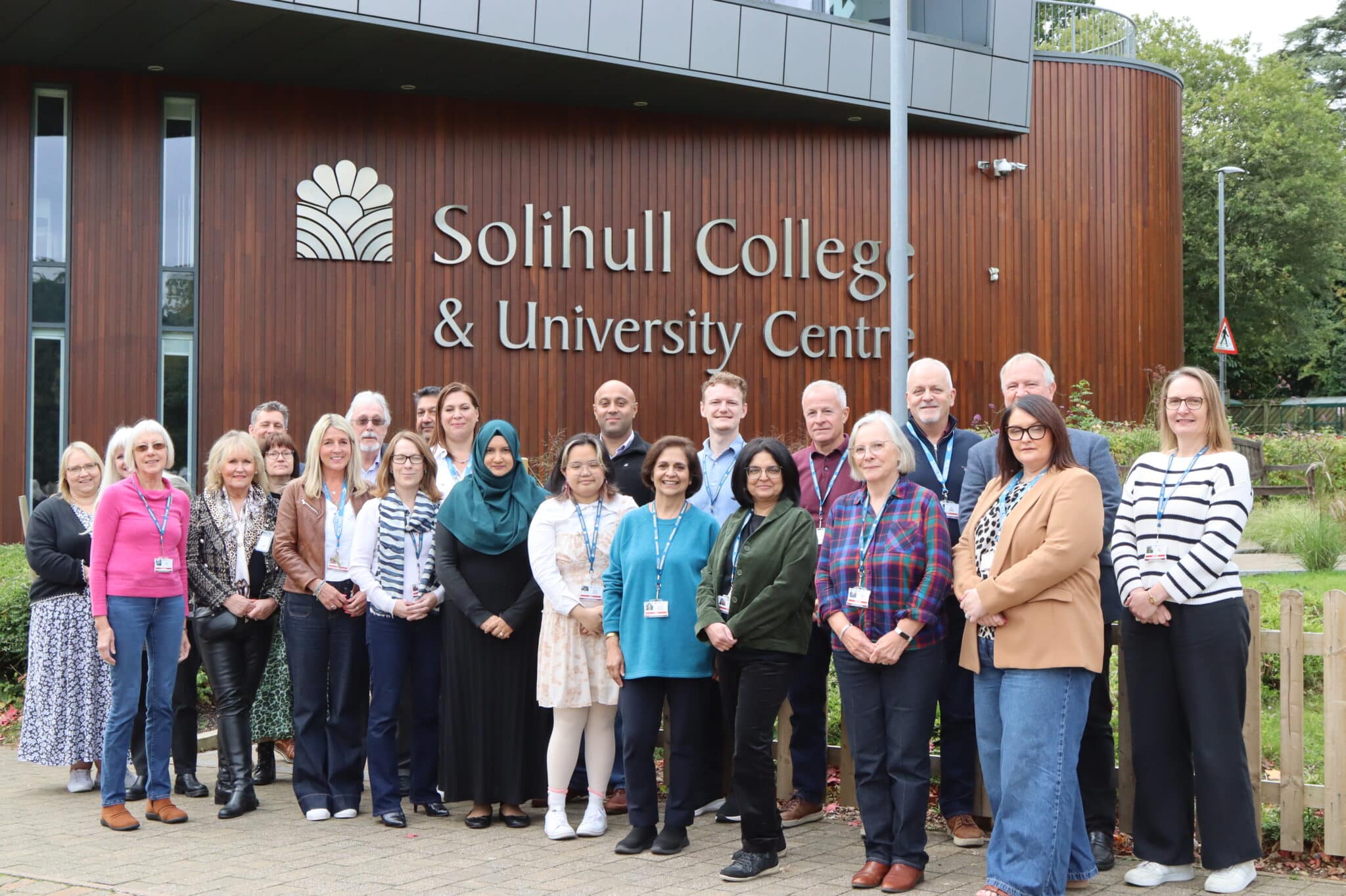 Group of Solihull College staff standing in front of college