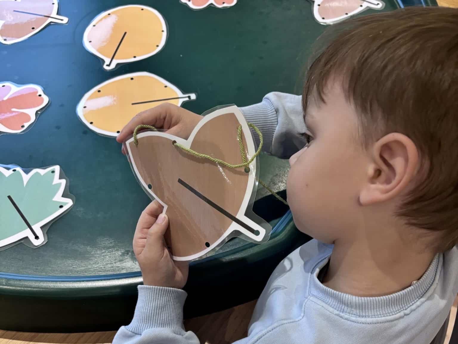 child playing with pictures of leaves