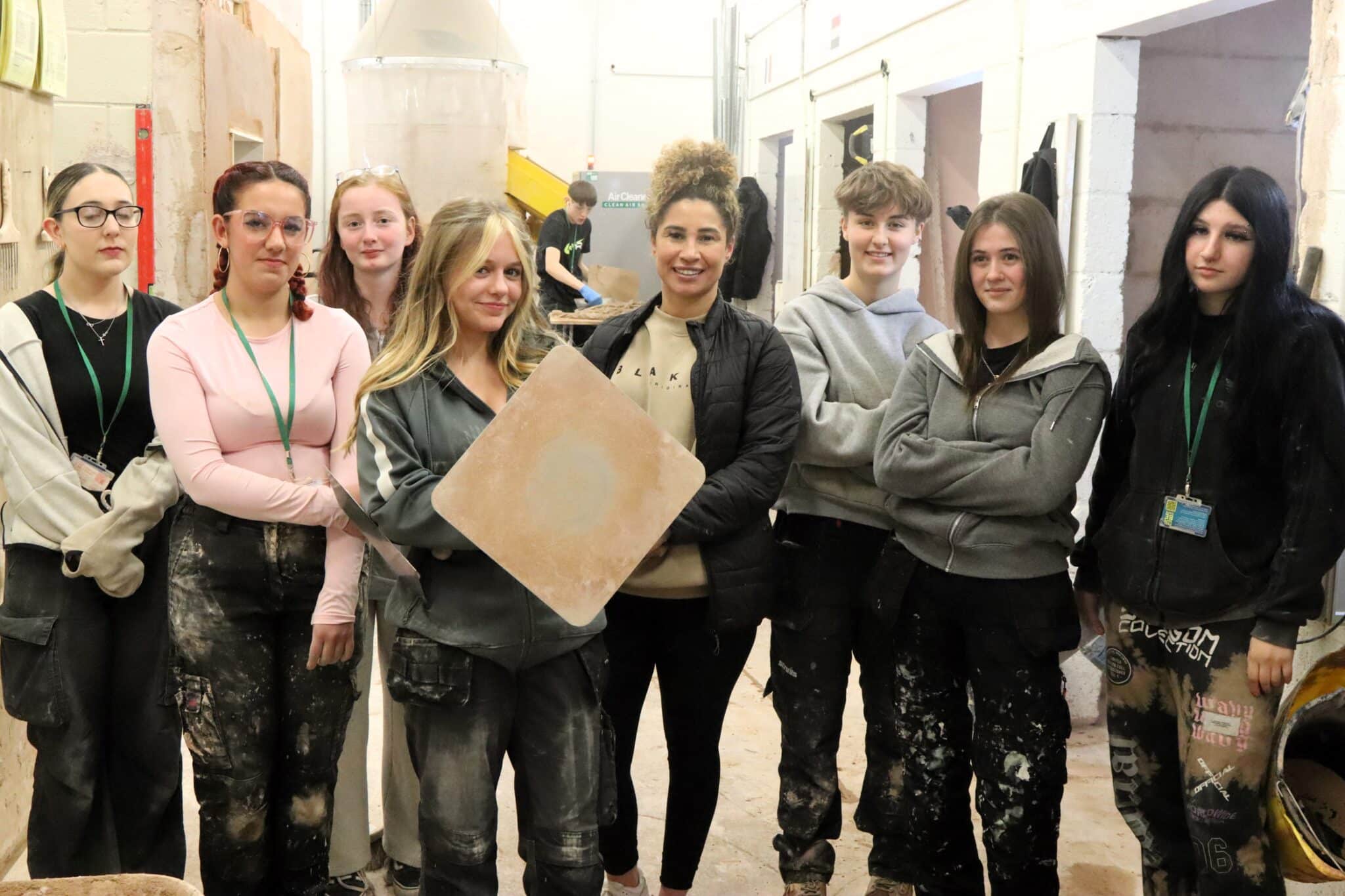 female plasterer standing with female plastering students