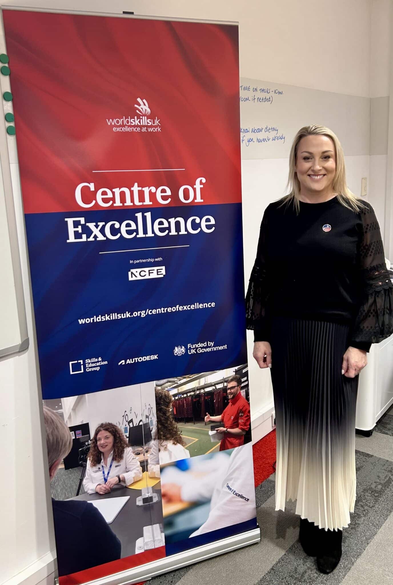 Katie Miller by a 'Centre of Excellence' banner