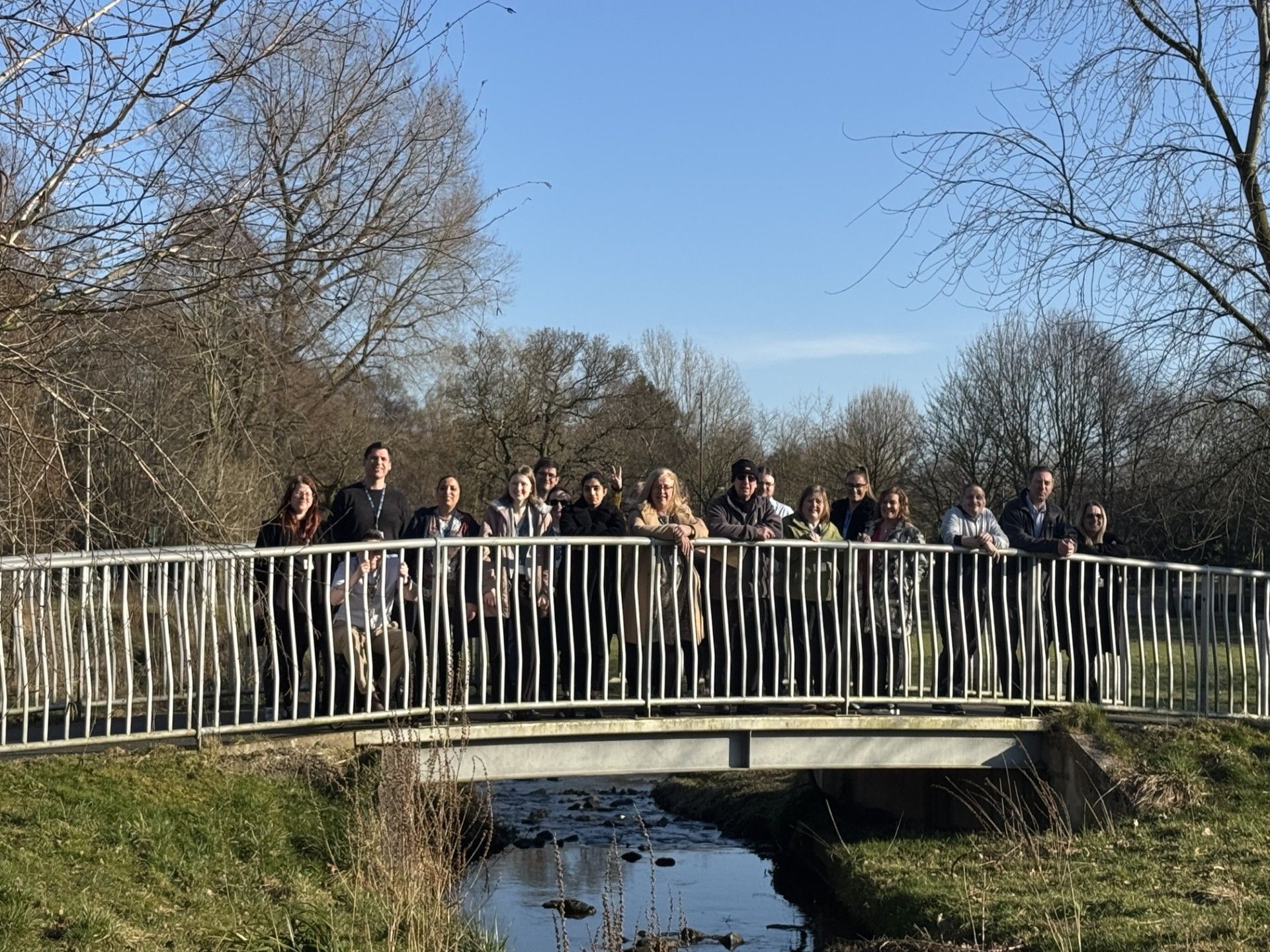 staff standing on a bridge in the park with blue sky